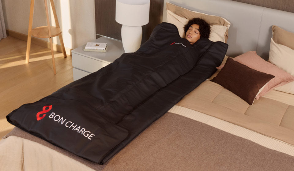 Woman Laying In Sauna Blanket On Bed