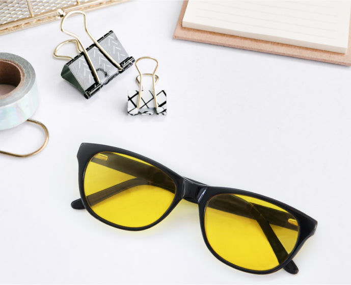 an overhead view of a pair of yellow lens, light sensitivity glasses